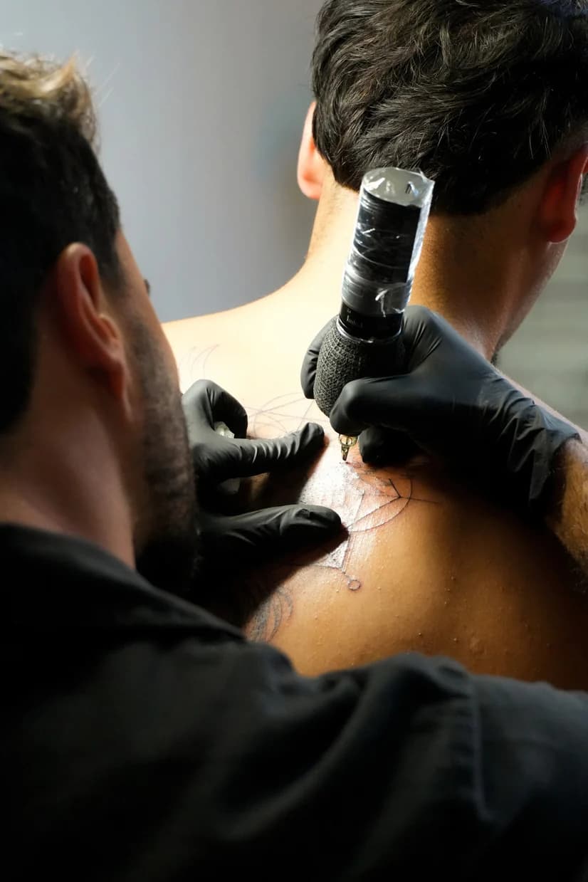 Pormenor de Daniel a trabalhar numa tatuagem no ombro.